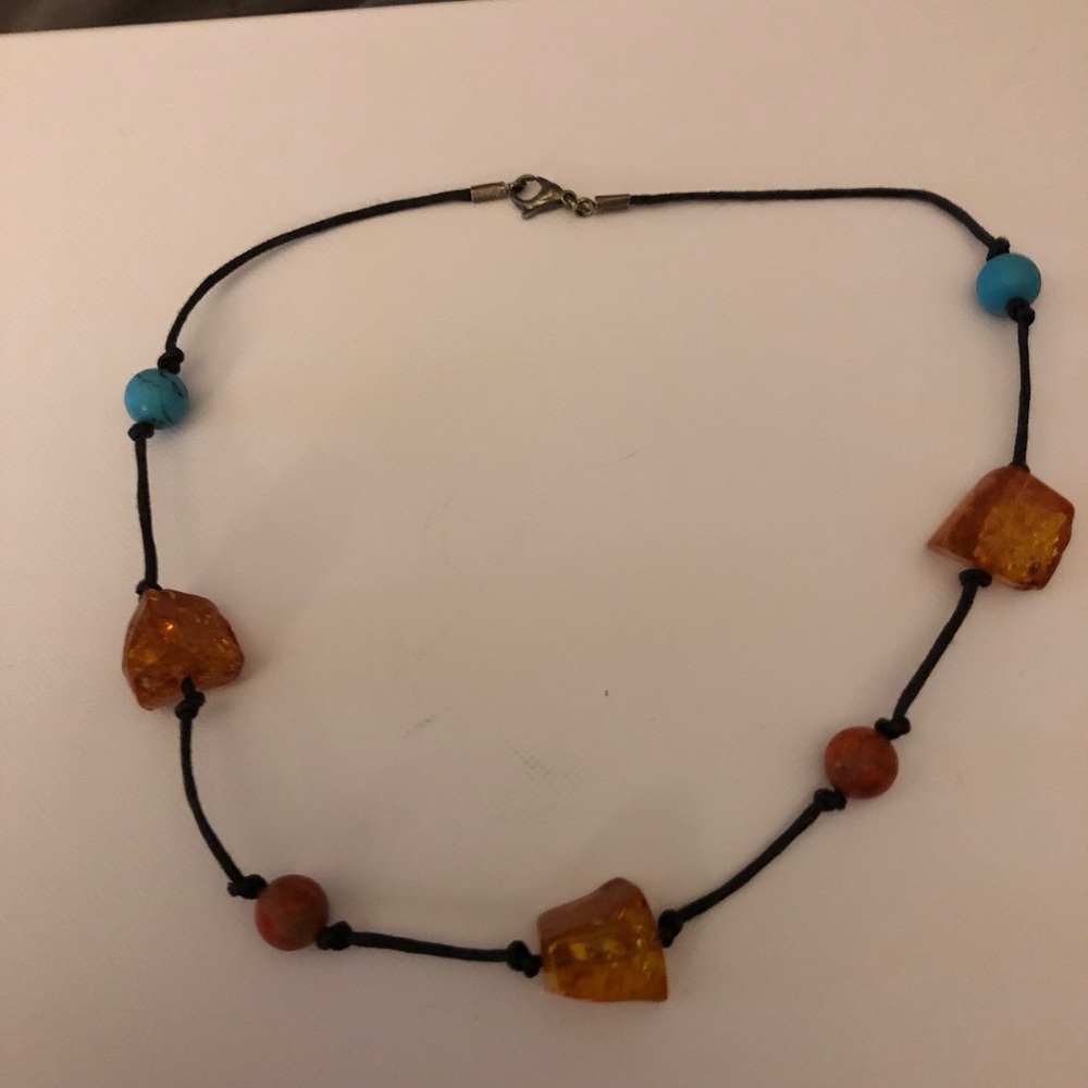 Amber and turquoise necklace on leather .